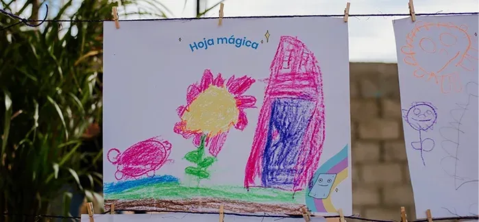Dibujos infantiles de colores colgados de un tendedero con pinzas
