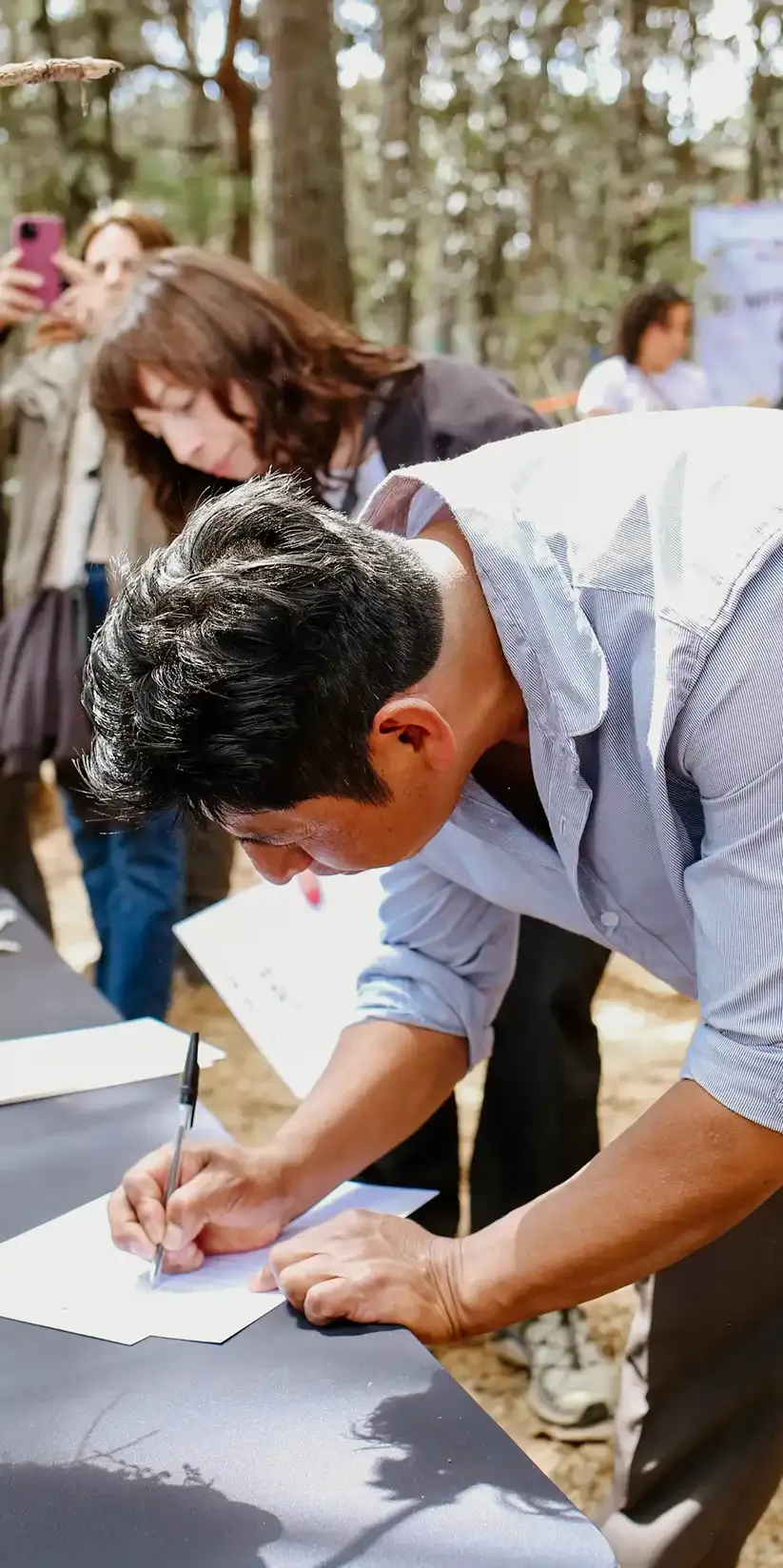 Integrante de la comunidad firmando durante la ceremonia de activación